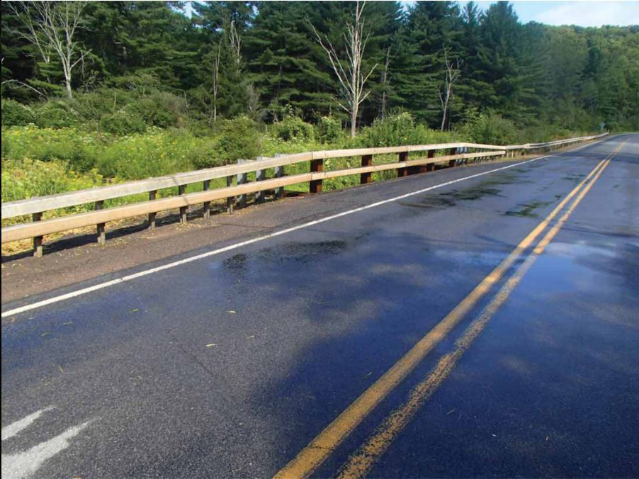 Roadway with guardrail running alongside.