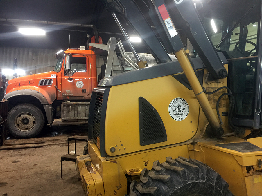 Side view of heavy equipment inside maintenance building.